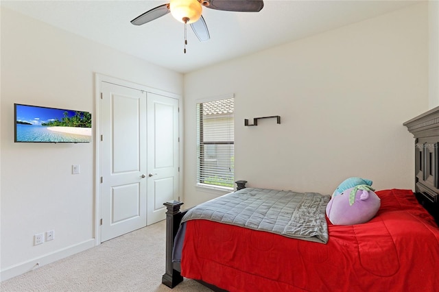 carpeted bedroom with ceiling fan and a closet