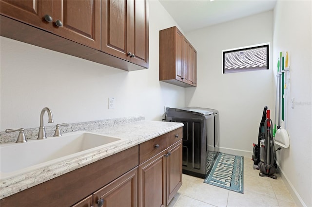 laundry area with washer and dryer, cabinets, light tile patterned floors, and sink