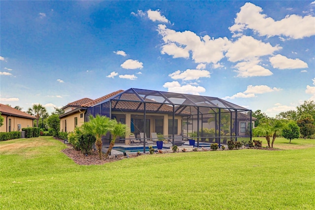 back of property with a lawn, glass enclosure, and a swimming pool