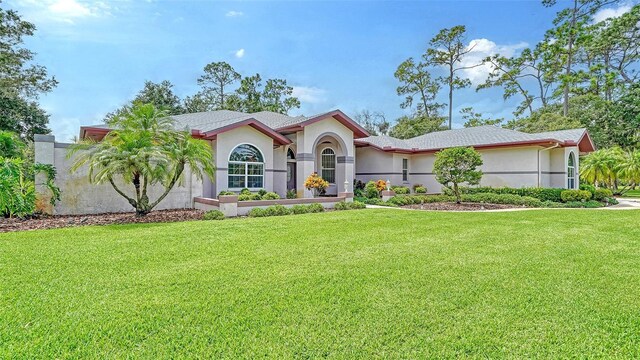 7430 Weeping Willow Dr, Sarasota, FL 34241 - mediterranean / spanish house featuring a front yard and stucco siding