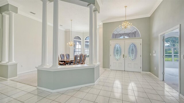7430 Weeping Willow Dr, Sarasota, FL 34241 - foyer featuring ornate columns, light tile patterned floors, and a notable chandelier
