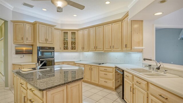 7430 Weeping Willow Dr, Sarasota, FL 34241 - kitchen featuring light brown cabinets, light tile patterned floors, dobule oven black, dishwashing machine, and a sink