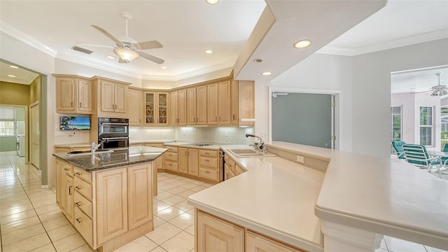 kitchen with kitchen peninsula, light brown cabinetry, light tile patterned floors, and sink