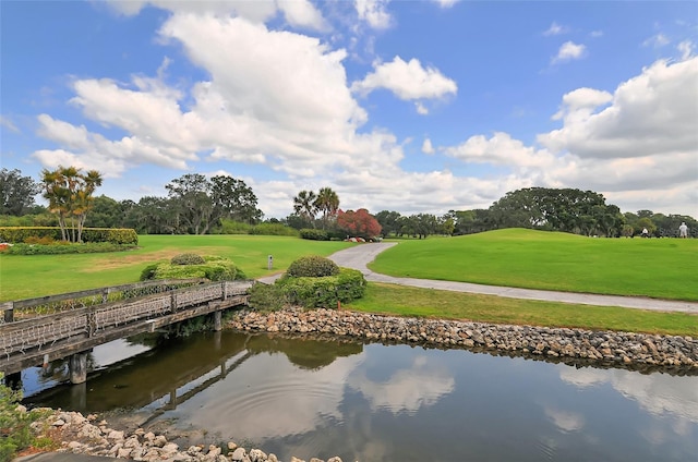 view of dock with a lawn and a water view