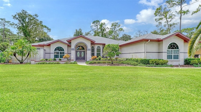 mediterranean / spanish house featuring a front lawn