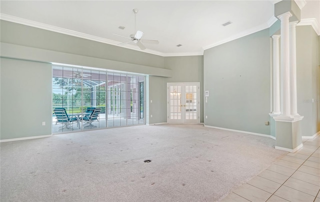 carpeted spare room featuring french doors, ceiling fan, crown molding, and decorative columns