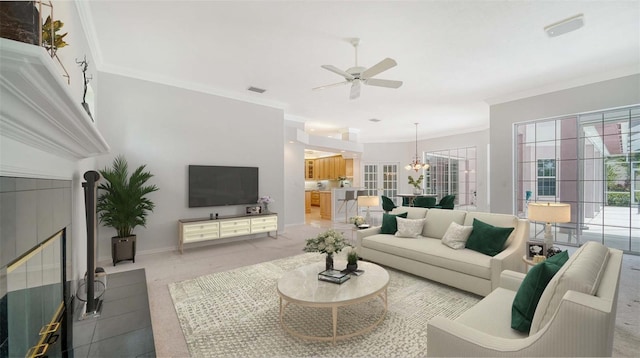 living room featuring ornamental molding and ceiling fan with notable chandelier