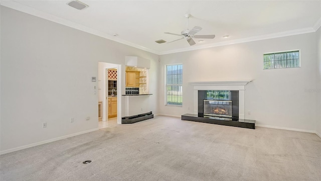 unfurnished living room with a tile fireplace, ceiling fan, a healthy amount of sunlight, and light colored carpet