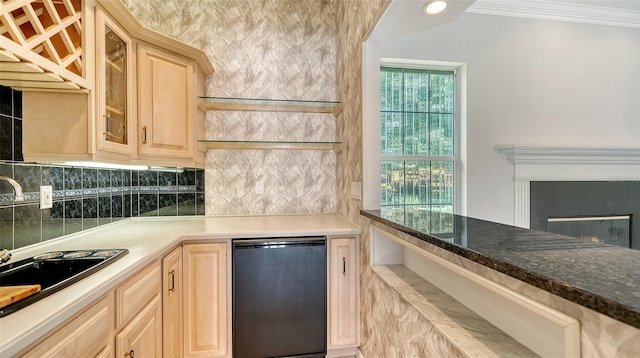 kitchen with sink, fridge, a tiled fireplace, ornamental molding, and light brown cabinetry