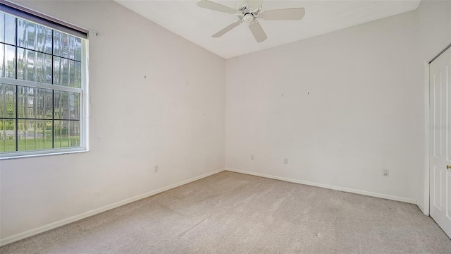 empty room with ceiling fan and light carpet