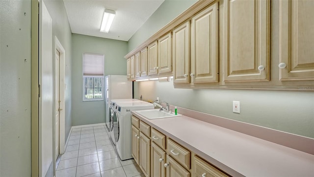 clothes washing area featuring cabinets, washer and dryer, light tile patterned floors, a textured ceiling, and sink