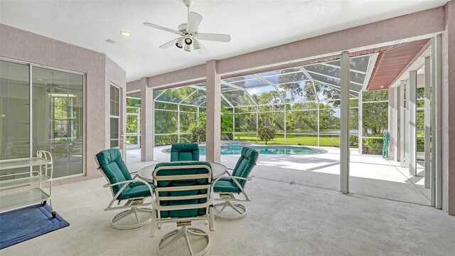 sunroom with ceiling fan and a pool