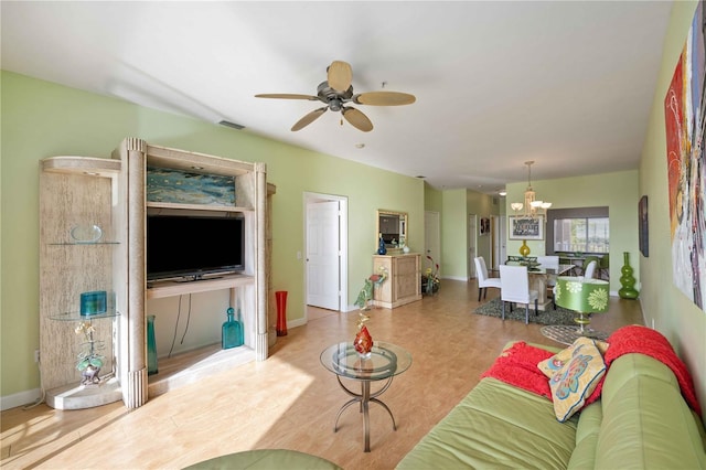 living room featuring ceiling fan with notable chandelier