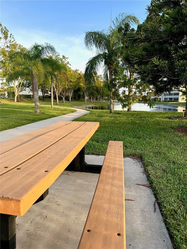 view of property's community with a yard and a water view