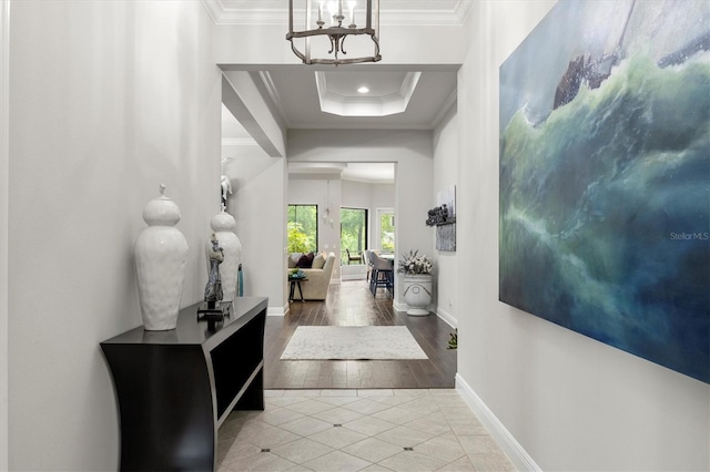 corridor featuring ornamental molding, light tile patterned floors, and an inviting chandelier