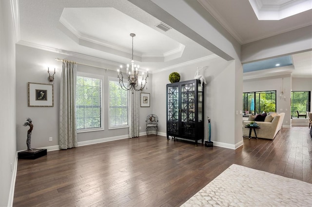 dining room featuring ornamental molding, dark wood-type flooring, and a tray ceiling