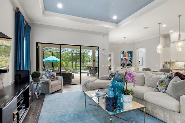 living room featuring a tray ceiling, crown molding, and dark wood-type flooring