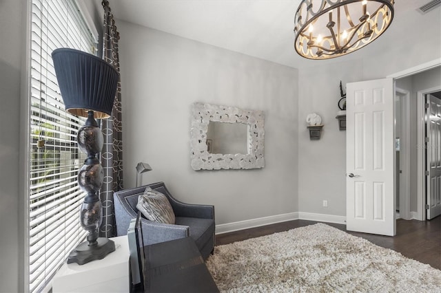 sitting room featuring dark wood-type flooring, plenty of natural light, and a chandelier