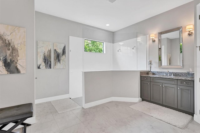 bathroom featuring tiled shower and vanity