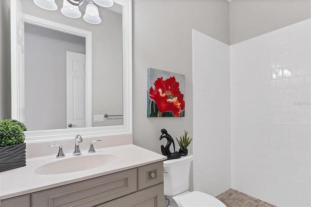 bathroom featuring a shower, vanity, and toilet