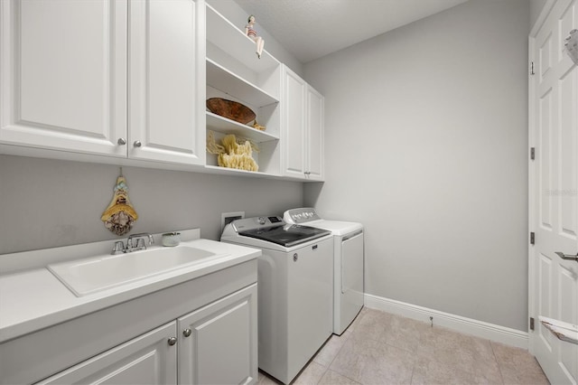 laundry room featuring washer and dryer, light tile patterned flooring, cabinets, and sink