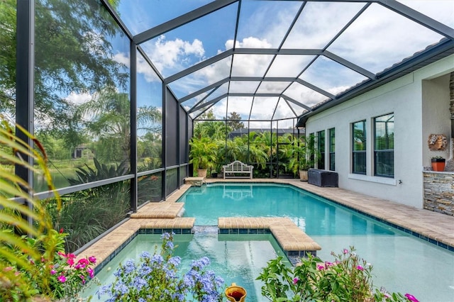 view of pool featuring an in ground hot tub, glass enclosure, and a patio area