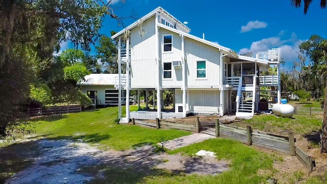 back of house with a sunroom and a yard