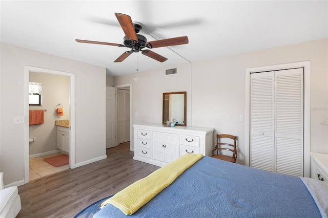 bedroom featuring ensuite bathroom, ceiling fan, dark hardwood / wood-style flooring, and a closet