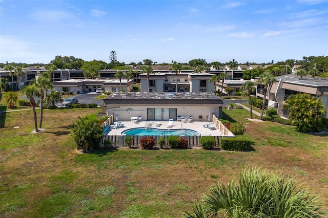 back of property with a fenced in pool, a patio area, and a yard