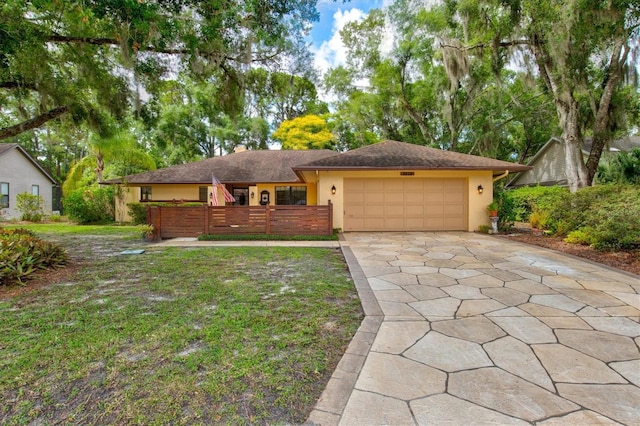 ranch-style home with a garage and a front lawn