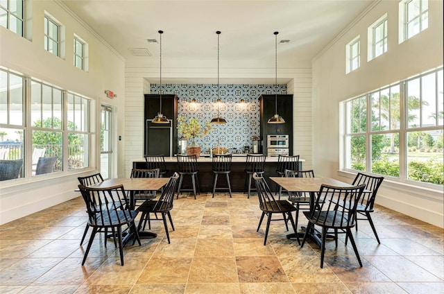 dining space with crown molding and a towering ceiling