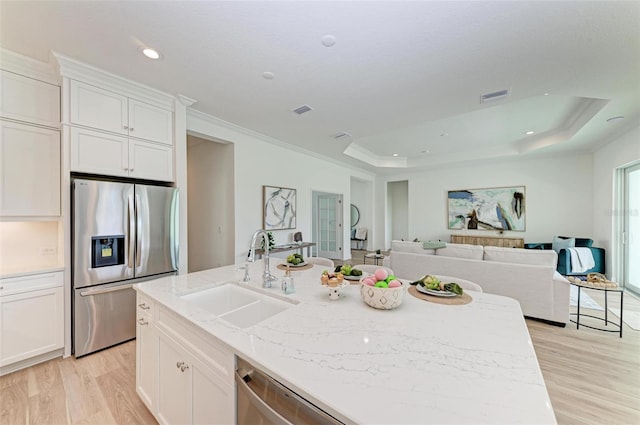 kitchen with sink, stainless steel appliances, a raised ceiling, and white cabinets