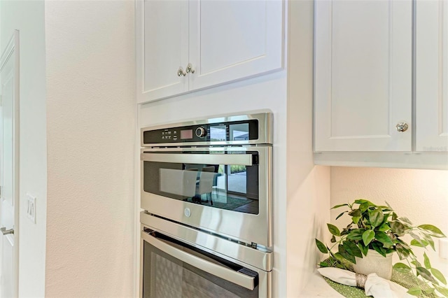 kitchen featuring white cabinetry and stainless steel double oven