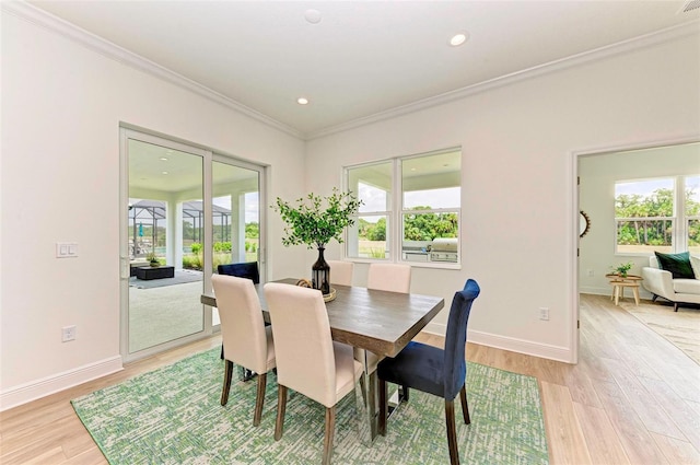 dining space featuring crown molding and light hardwood / wood-style floors