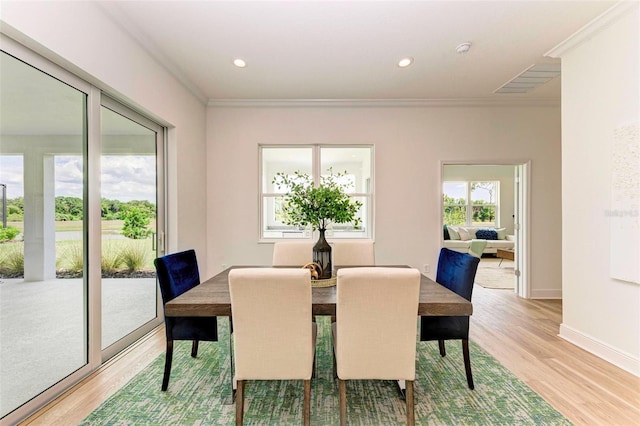 dining room featuring crown molding and light hardwood / wood-style flooring