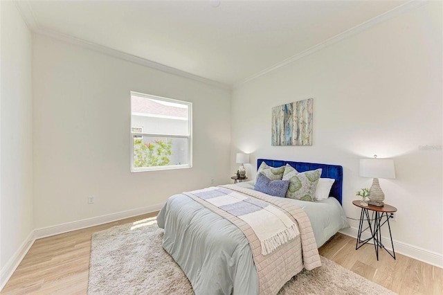 bedroom featuring crown molding and light hardwood / wood-style floors