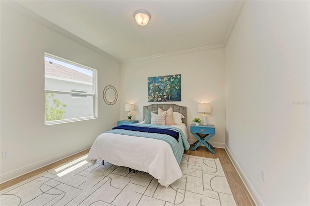 bedroom with ornamental molding and light hardwood / wood-style flooring