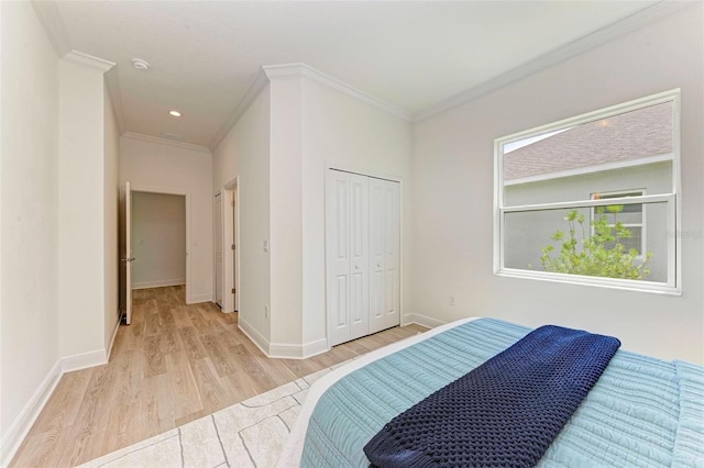 bedroom with crown molding, light hardwood / wood-style floors, and a closet