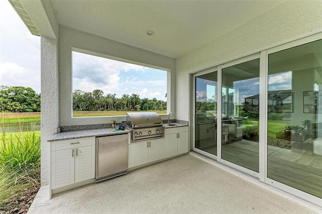 view of patio / terrace featuring exterior kitchen, a grill, and sink