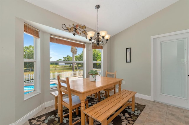 dining room with vaulted ceiling, light tile patterned flooring, a chandelier, and a healthy amount of sunlight