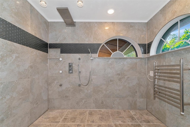 bathroom featuring crown molding, a tile shower, and radiator