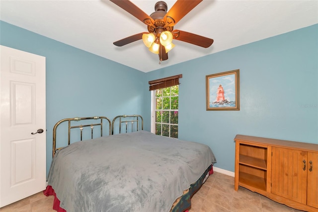 tiled bedroom featuring ceiling fan