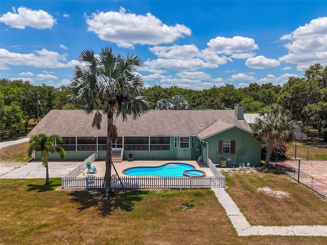 view of pool featuring a patio, a sunroom, and a lawn