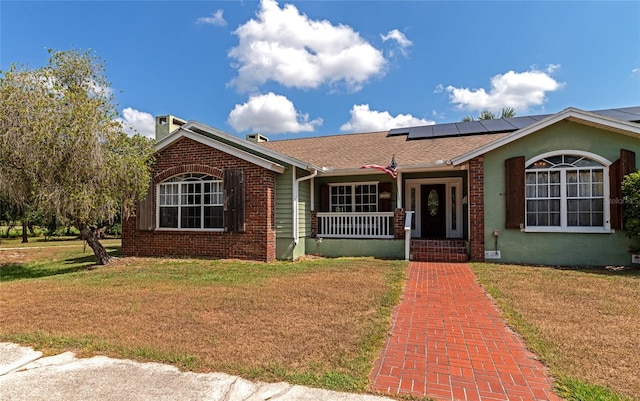 view of front of home with solar panels, a porch, and a front lawn