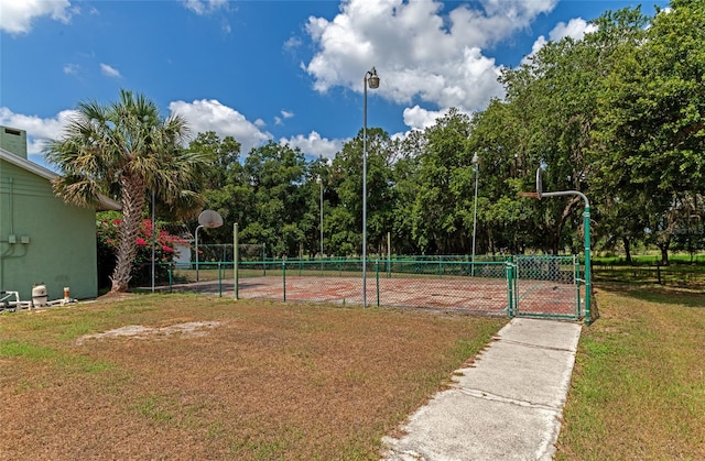 view of community featuring basketball court and a lawn