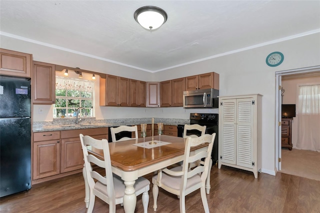 dining room with ornamental molding, dark hardwood / wood-style floors, and sink