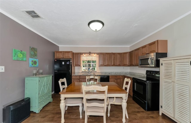 kitchen featuring black appliances, dark wood-type flooring, crown molding, and sink