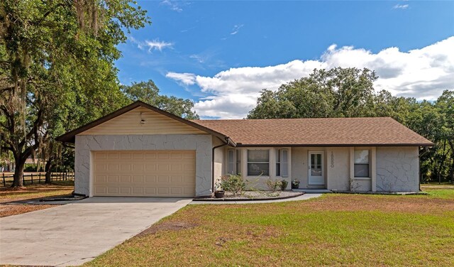 ranch-style house featuring a front lawn and a garage