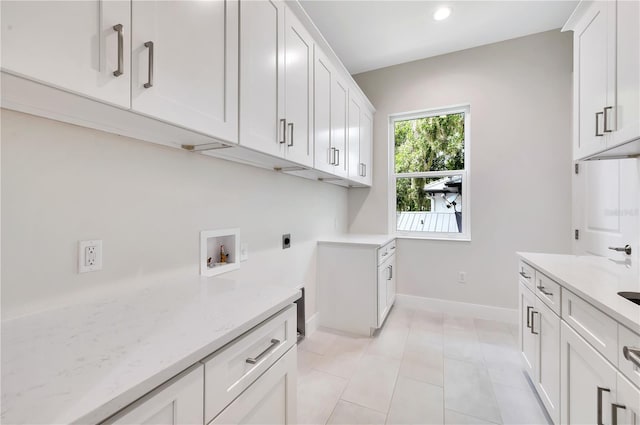 laundry room featuring electric dryer hookup, washer hookup, and cabinets