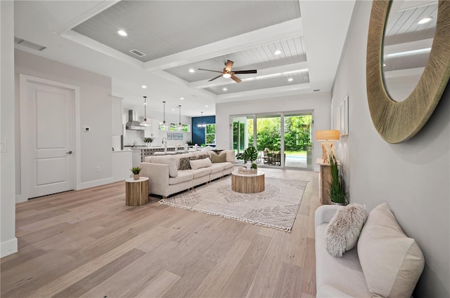 living room featuring ceiling fan, light hardwood / wood-style flooring, wooden ceiling, and beamed ceiling